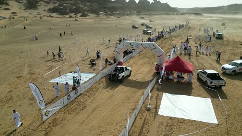 A starting or stopping area for the rally in a desert area, a competition with diverse terrain in Tabuk, a rally racing event in the Kingdom of Saudi Arabia, a speed race for cars, preparing the place for enjoyable recreational youth sports, the turns and directions for the competing cars.