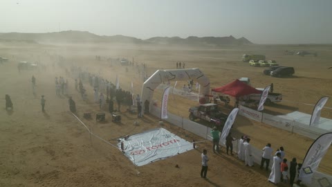 A starting or stopping area for the rally in a desert area, a competition with diverse terrain in Tabuk, a rally racing event in the Kingdom of Saudi Arabia, a speed race for cars, preparing the place for enjoyable recreational youth sports, the turns and directions for the competing cars.