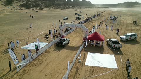 A starting or stopping area for the rally in a desert area, a competition with diverse terrain in Tabuk, a rally racing event in the Kingdom of Saudi Arabia, a speed race for cars, preparing the place for enjoyable recreational youth sports, the turns and directions for the competing cars.