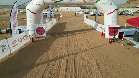 Strong competition between local and regional drivers, a desert race with diverse terrain in Tabuk, a rally racing event in the Kingdom of Saudi Arabia, car speed racing, preparing the venue for enjoyable recreational youth sports, the turns and directions for the competing cars.