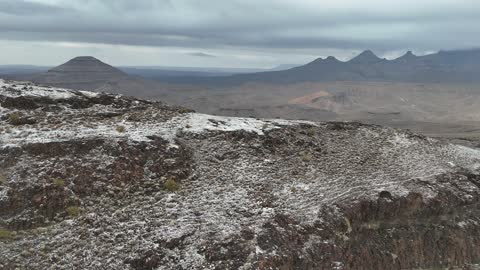 ارتداء ملابس ثقيلة ومعدات خاصة،  معالم حضارية سياحية في المملكة العربية السعودية، أجواء الثلجية الباردة، سلسلة جبال الحرة في منطقة تبوك تكسوها الثلوج، جبال منحوتة وتشكيلات جبلية، تصوير درون جوي للتكوينات الصخرية