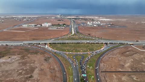 زخات من المطر وغيوم في السماء ،  تجمع مياه الأمطار وسط المنطقة, منخفض جوي، امطار شتوية، أماكن ومناطق السياحة في المملكه العربية السعودية، تصوير درون للسيل في مدينة تبوك ,معالم سياحية مشهورة