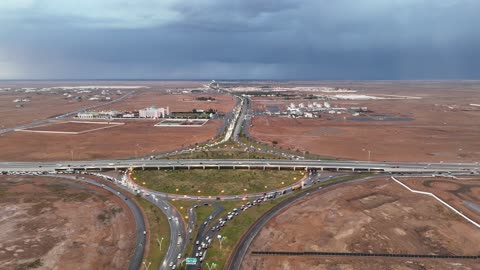 زخات من المطر وغيوم في السماء ،  تجمع مياه الأمطار وسط المنطقة, منخفض جوي، امطار شتوية، أماكن ومناطق السياحة في المملكه العربية السعودية، تصوير درون للسيل في مدينة تبوك ,معالم سياحية مشهورة