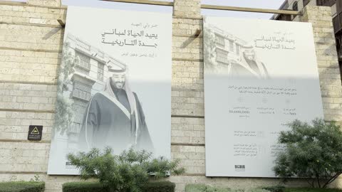 لافتة باللون الأبيض والأسود معلقة على جدار حجري، الفنون المعمارية في المدينة التاريخية في جدة، تصوير للحارات والتصاميم الشعبية، الأماكن السياحية في المملكة العربية السعودية، المباني الأثرية القديمة، مشاريع إعادة إحياء المنطقة