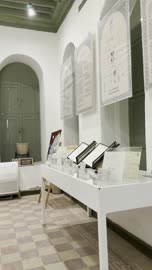 أقواس على الحائط وثريا معلقة في السقف، معلومات في إطار تعليمي أو بحثي، المستندات الشخصية والرسمية، وثائق تاريخية وأرشيفية معروضة في متحف في جدة التاريخية في المملكة العربية السعودية، مقتنيات تذكارية وعناصر ذات قيمة ثقافية.