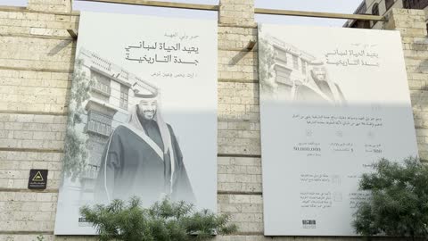 لافتة باللون الأبيض والأسود معلقة على جدار حجري، الفنون المعمارية في المدينة التاريخية في جدة، تصوير للحارات والتصاميم الشعبية، الأماكن السياحية في المملكة العربية السعودية، المباني الأثرية القديمة، مشاريع إعادة إحياء المنطقة