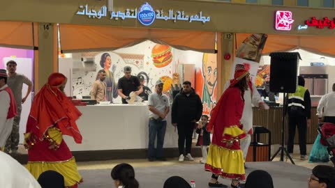 Traditional folk dance in front of one of the restaurants in Global Village in the Eastern Province, Kingdom of Saudi Arabia, on December 29, 2025, local and international brands, family activities and interactive experiences, a comprehensive cultural and entertainment event, cultural diversity and entertainment.