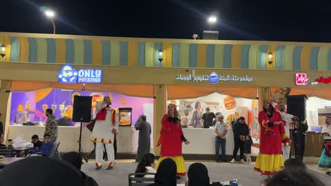 رقص شعبي تقليدي امام احدى المطاعم فى القرية العالمية فى المنطقة الشرقية، المملكة العربية السعودية، يوم 29 من ديسمبر 2025 ، علامات تجارية محلية وعالمية ، أنشطة عائلية وتجارب تفاعلية، فعالية ثقافية وترفيهية متكاملة،  التنوع الثقافي والترفيه