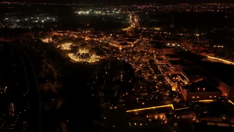 A famous Saudi cultural, tourist, and historical center and landmark at night, the illuminated Al-Bujairi Park and overlook during the day, the cultivation of plants and green palm trees, the development project of historical Diriyah in the city of Riyadh, Saudi Arabia, the heritage village and archaeological buildings.