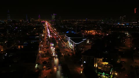 The capital of Riyadh, the skyline of the city of Riyadh, urban growth and development, the famous roads, streets, and landmarks of Riyadh, traffic movement, drone photography of the illuminated towers and skyscrapers at night in the city of Riyadh in the Kingdom of Saudi Arabia, architectural engineering art.