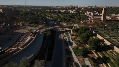 زراعة النباتات وأشجار النخيل الخضراء, مشروع تطوير الدرعية التاريخية في مدينة الرياض بالمملكة العربية السعودية، منتزه ومطل البجيري المضاء في النهار، مركز ومعلم ثقافي سياحي تاريخي سعودي مشهور، القرية التراثية والمباني الاثرية