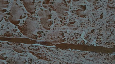 جبال مغطا بالثلوج وتشكيلات جبلية، معالم حضارية سياحية في المملكة العربية السعودية، سماء ملبدة بالغيوم ، أجواء الثلجية الباردة، سلسلة حائل عروس الشمال تكسوها الثلوج، تصوير درون جوي للتكوينات الصخرية