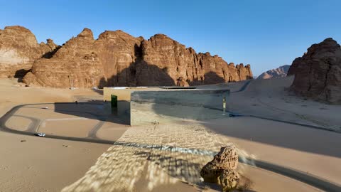 The Mirror Theater in the desert of Al-Ula Governorate, desert tourist attractions, mountain ranges and highlands, a historical archaeological site in the middle of the deserts of the Kingdom of Saudi Arabia, soft golden sands, rock formations and structures, attracting and drawing tourists from all over the world.