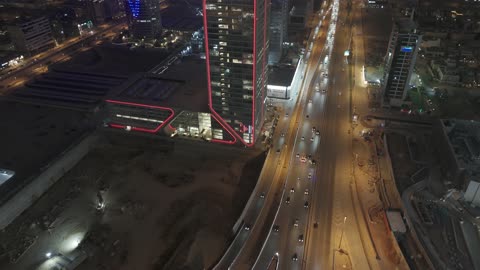 الفن الهندسي المعماري على الطراز المتطور للأبراج وناطحات السحاب في مدينة الرياض، نمط الحياة في العاصمة، النمو والتطور والتقدم العمراني،  تصوير درون لبرج بنك ساب في وقت الليل، المباني والمعالم التجارية المشهورة في المملكة العربية السعودية، طريق الملك فهد