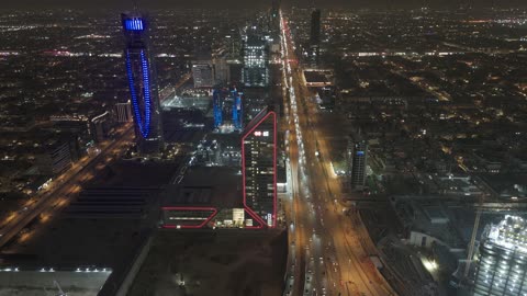 الفن الهندسي المعماري على الطراز المتطور للأبراج وناطحات السحاب في مدينة الرياض، نمط الحياة في العاصمة، النمو والتطور والتقدم العمراني،  تصوير درون لبرج بنك ساب في وقت الليل، المباني والمعالم التجارية المشهورة في المملكة العربية السعودية، طريق الملك فهد