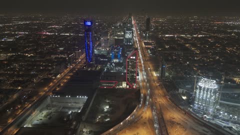 الفن الهندسي المعماري على الطراز المتطور للأبراج وناطحات السحاب في مدينة الرياض، نمط الحياة في العاصمة، النمو والتطور والتقدم العمراني،  تصوير درون لبرج بنك ساب في وقت الليل، المباني والمعالم التجارية المشهورة في المملكة العربية السعودية، طريق الملك فهد