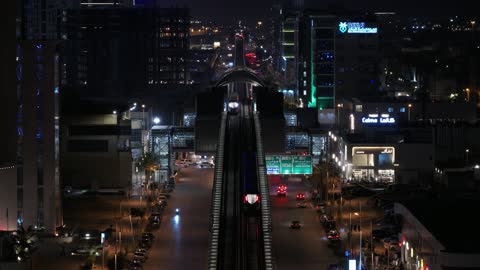 Traffic in the city of Riyadh, drone footage of the high-speed train running on the railway, the architectural engineering art of modern-style towers and skyscrapers, buildings and economic facilities in the Kingdom of Saudi Arabia, modern transportation means.