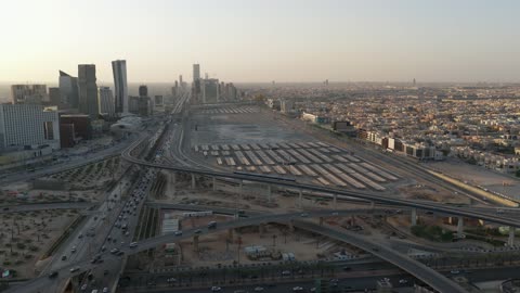 Traffic in the city of Riyadh, drone footage of the high-speed train running on the railway, the architectural engineering art of modern-style towers and skyscrapers, buildings and economic facilities in the Kingdom of Saudi Arabia, modern transportation means.