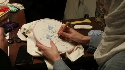 اتقان فن العمل اليددوي، قضاء وقت الفراغ بشء نافع، تصوير مقرب لامرأة تقوم بعمل تطريز يدوي باستخدام الإبرة