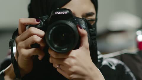 Mastering the art of photography, a professional Arab Gulf Saudi photographer captures artistic shots using a professional camera.