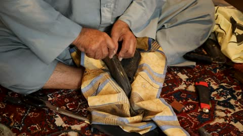 تصوير مقرب لحرفي ماهر يقوم بإصلاح حذاء تقليدي بشكل يدوي، حرفة يدوية تقليدية قديمة