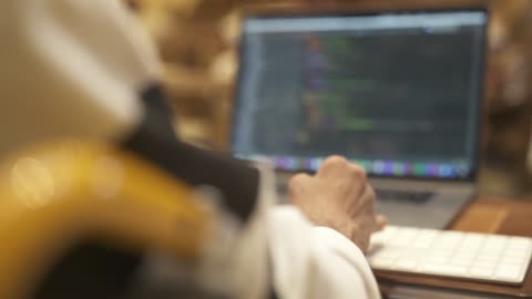 دمج اصحاب الهمم في المجتمع في المملكة العربية السعودية، تصوير مقرب لمبرمج من ذوي الإعاقة يعمل بتركيز على الكمبيوتر