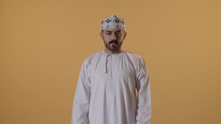 الشعور بالنعاس والحاجة للنوم، ضرورة أخذ قسط من الراحة والاسترخاء، إيماءات التعب والإرهاق، بورتريه لرجل عربي خليجي عماني يرتدي الدشداشة و الكمة يفتح يديه بتعابير التمدد، خلفية برتقالية