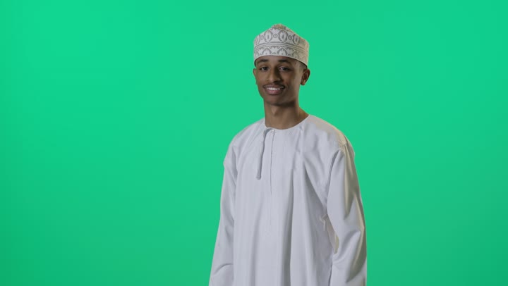 شاب عماني بالزي التقليدي أمام خلفية خضراء