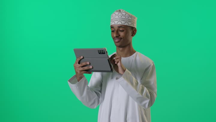 Omani Man Using Digital Tablet on Green Screen