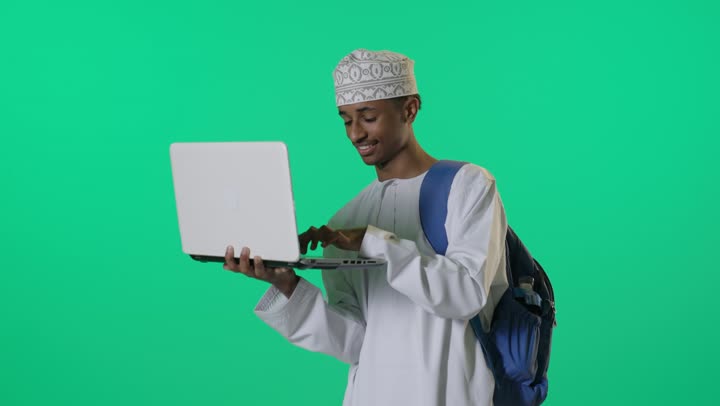 طالب عماني يستخدم الحاسوب المحمول خلفية كروما خضراء