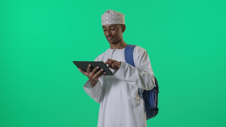 Omani Student Using Tablet on Green Screen