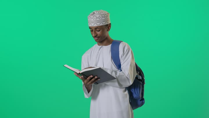 Omani Student Reading Book on Green Screen