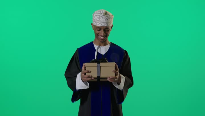 Omani Graduate Holding Gift Box on Green Screen