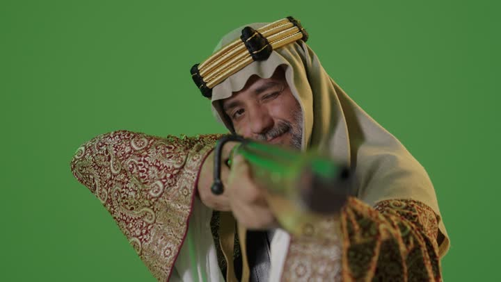 On the day we started, February 22, wearing traditional attire for a national occasion, the anniversary of the founding of the first Saudi state in 1727, the concept of love for the homeland and belonging to it, a portrait of an elderly Arab Gulf Saudi man wearing a bisht and agal standing and holding a Saudi rifle, green background, chroma.