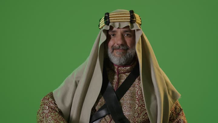 A portrait of an elderly Arab Gulf Saudi man wearing a bisht and agal, holding a sword in his hand, representing the concept of love for the homeland and belonging to it, the anniversary of the founding of the first Saudi state in 1727, the concept of love for the homeland and belonging to it, Founding Day on February 22, wearing traditional attire on a national occasion, green background, chroma.