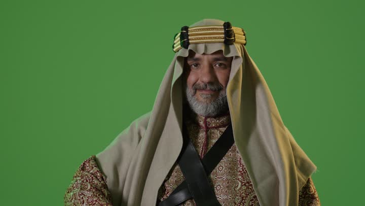 Anniversary of the establishment of the first Saudi state in 1727, the concept of love for the homeland and belonging to it, the day we started on February 22, wearing traditional attire on a national occasion, a side portrait of an elderly Arab Gulf Saudi man wearing a bisht and agal holding a sword in his hand, green background, chroma.