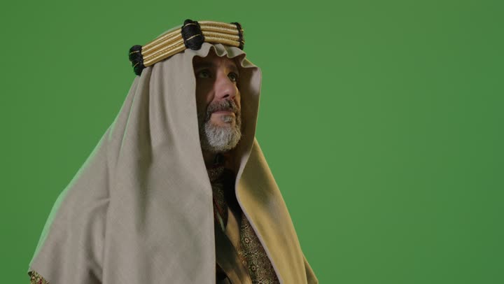 A portrait of an elderly Arab Gulf Saudi man wearing a bisht and agal, looking with expressions of pride, dignity, and happiness, dressed in traditional attire for a national occasion, embodying the concept of love for the homeland and belonging to it, on the day we began, February 22, the anniversary of the founding of the first Saudi state in 1727, with a green background, chroma.