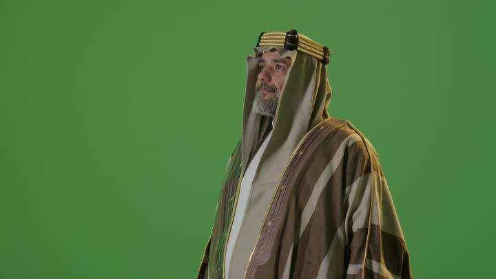 ذكرى تأسيس الدولة السعودية الأولى1727م,  مفهوم حب الوطن والانتماء اليه, يوم بدينا 22 فبراير, ارتداء الزي الشعبي في مناسبة وطنية, بورتريه من الجانب لرجل كبير بالسن عربي خليجي سعودي يرتدي البشت والعقال ينظر بتعابير الفخر، خلفية خضراء، كروما