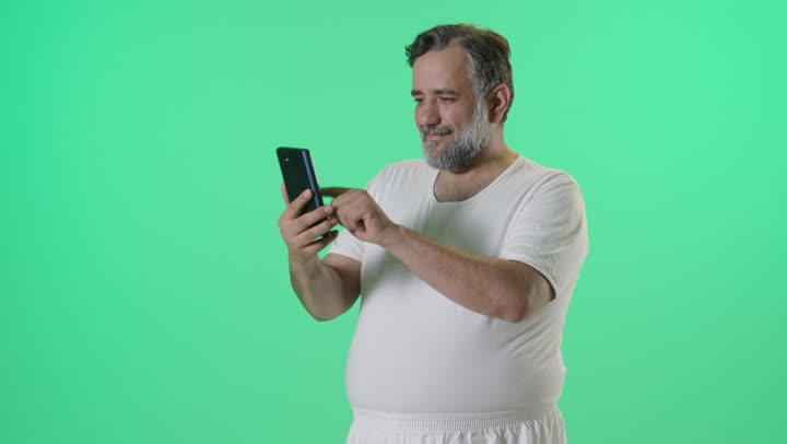 رجل يستخدم الهاتف الذكي أمام خلفية خضراء