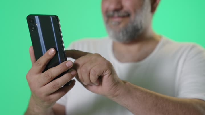 رجل عربي يستخدم الهاتف الذكي أمام خلفية كروما خضراء