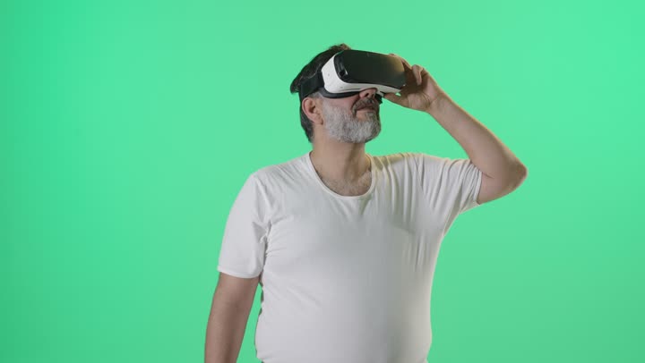 رجل يرتدي نظارة واقع افتراضي على خلفية خضراء