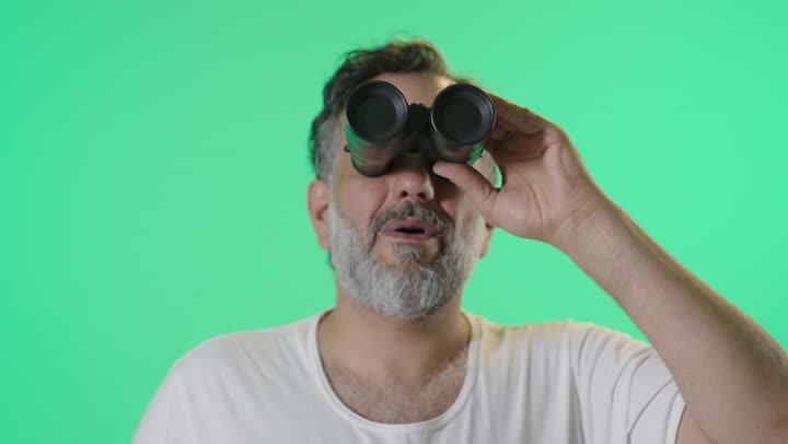 Man Looking Through Binoculars on Green Screen