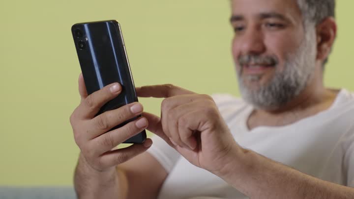Arab Man Using Smartphone on Yellow Background
