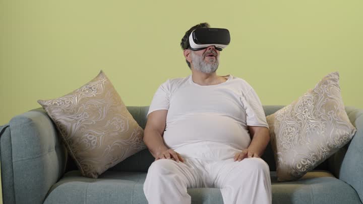 Arab Man Wearing VR Headset Sitting On Sofa Indoors Video