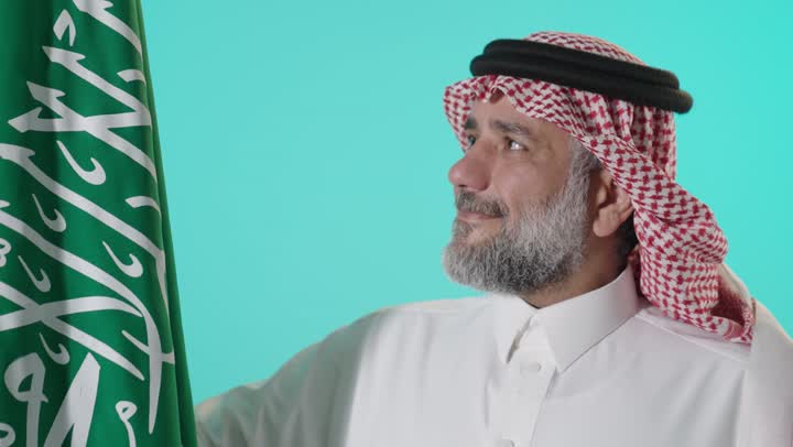 رجل سعودي مع العلم الوطني في الاستوديو