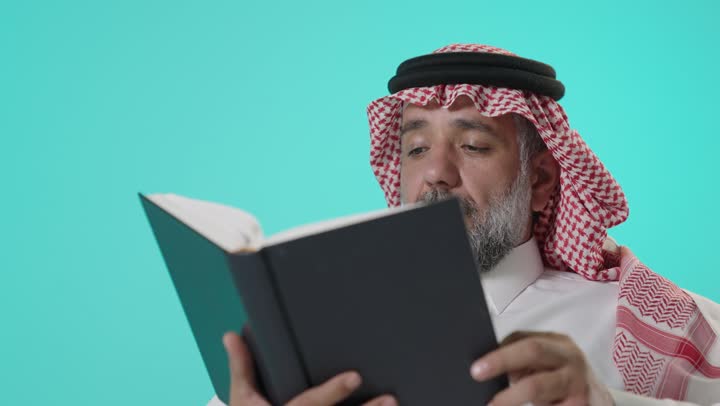 رجل سعودي يقرأ كتاباً على خلفية فيروزية