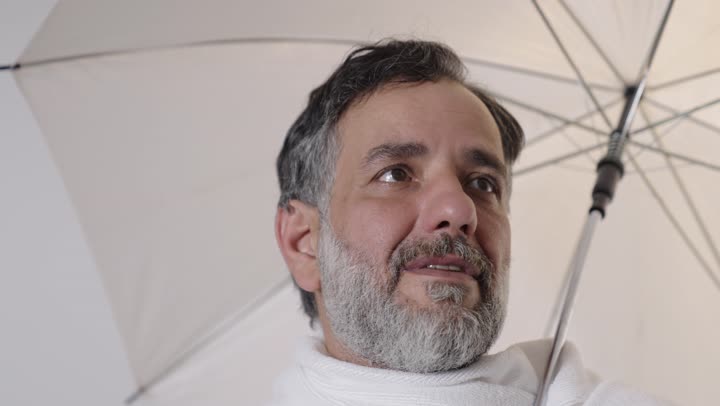 حاج عربي بملابس الإحرام يشرب الماء في الحج والعمرة