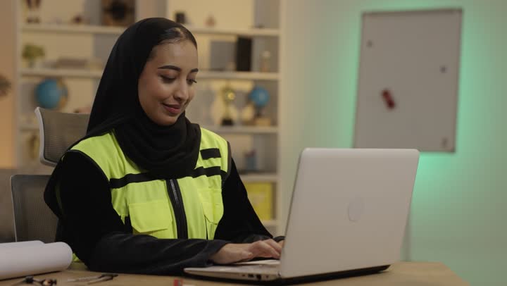Saudi Female Engineer Working on Laptop in Modern Office