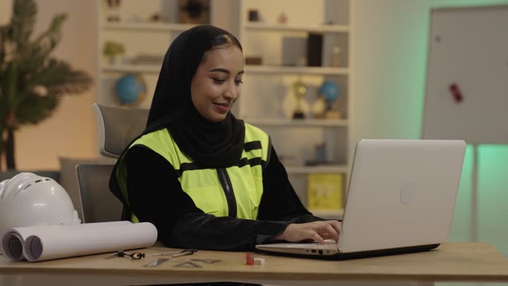 Saudi Female Engineer Working on Laptop in Office