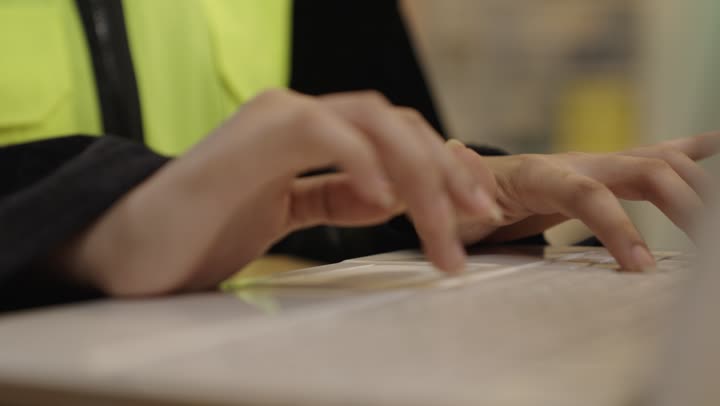 Arab Woman Typing on Laptop in Safety Vest